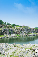 Fototapeta premium Sharp, white, marble-like rocky cliffs of Tarpania Lake, Marble Lake, Blue Dam, Patal Dam or Durga Bera,a scenic lake in the Ajodhya Hills of Purulia, West Bengal, India. Lake has Deep blue water.