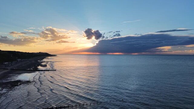 Drone view of sunset over sea with storm clouds