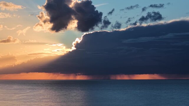 Aerial view of sunset over sea with storm clouds