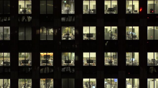 TOKYO, JAPAN : Close up shot of office building window at night. Job, work, company, corporate and business people concept time lapse video.
