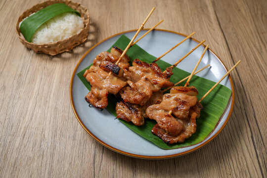 Close-up of Thai traditional grilled pork skewers (Moo Ping) with sticky rice.