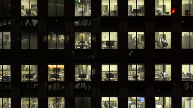 TOKYO, JAPAN : Close up shot of office building window at night. Job, work, company, corporate and business people concept time lapse video.