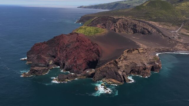 Aerial view of the volcanic landscape of Capelinhos with dark lava cliffs and coastal scenery in Capelo, Azores, Portugal.