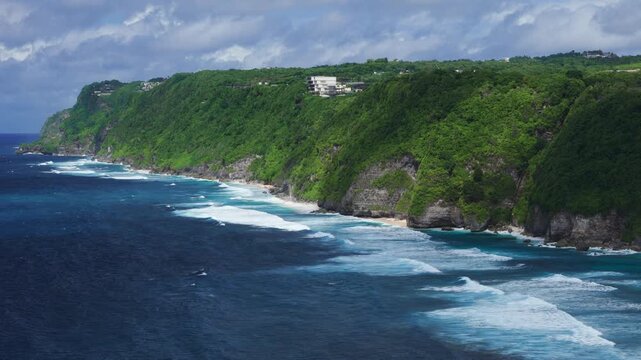 Scenic landscape with cliffs on tropical coastline with ocean and waves. Drone view, travel destination