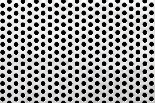 Close-up macro of a perforated satin stainless steel sheet with evenly spaced circular holes. The brushed metallic surface conveys precision manufacturing and industrial functionality.
