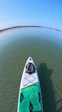 Stand up paddle boarding over crystal clear sea near beach