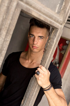 Serious young man posing in sunlight outdoors