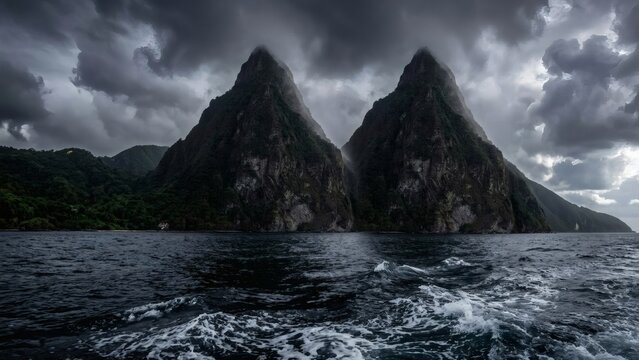 Towering volcanic spires of the Pitons rising from a dark churning ocean in Saint Lucia
