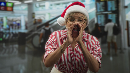 Fototapeta premium Woman cupping hands to mouth shouting in busy airport terminal wearing santa hat and striped shirt; festive cheer.