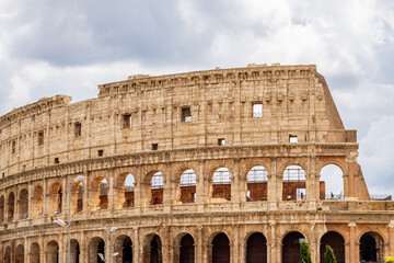 Obraz premium Famous tourist attraction of historic Colosseum amphitheatre with ancient stone arches in Rome Italy