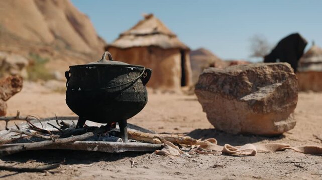 Cast iron pot an open campfire in a traditional african himba village in namibia, showing an authentic outdoor cooking scene
