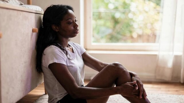Thoughtful Young Woman Sitting Alone Indoors Near Bright Window