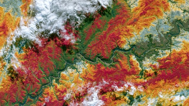A map-style composition of fall foliage viewed from space, with contiguous swaths of chlorophyll loss, temperature bands, and cloud shadows wrapping across mountain ranges and river valleys.