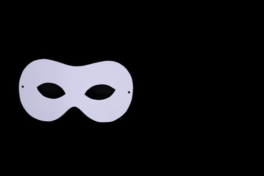 White mask on black background symbolizing hidden emotions identity and mental health