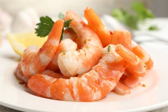 Tasty boiled shrimps with parsley on table against grey background, closeup