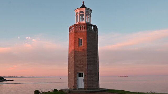 Groton, Connecticut, USA - Avery Point Lighthouse With Fishing Boats And Cargo Vessel On Long Island Sound