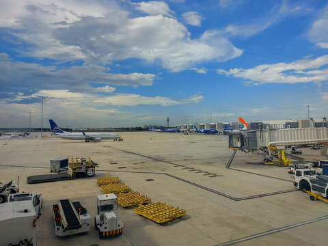 Aviation Hub: Wide-Angle Landscape View of Airplanes at Terminals Under a Cloudy Sky at Orlando International Airport, Florida