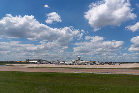 Aviation Hub: Wide-Angle Landscape View of Airplanes at Terminals Under a Cloudy Sky at Orlando International Airport, Florida