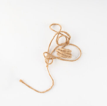 String piece isolated, jute rope fragment, part of packaging cord knots, eco-friendly natural rope
