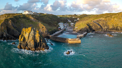 Fototapeta premium Aerial view from the sea of the Cornish fishing village of Mullion Cove and its historic harbour