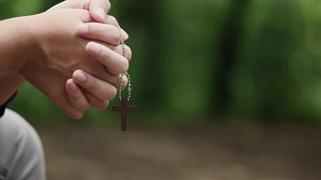 People sit outside, holding crosses, praying to God for hope, salvation, and the release of sorrow and grief, and for a broader understanding of Christianity. Concepts of Christianity
