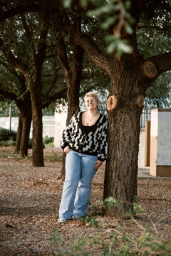 teen girl posing with tree in park