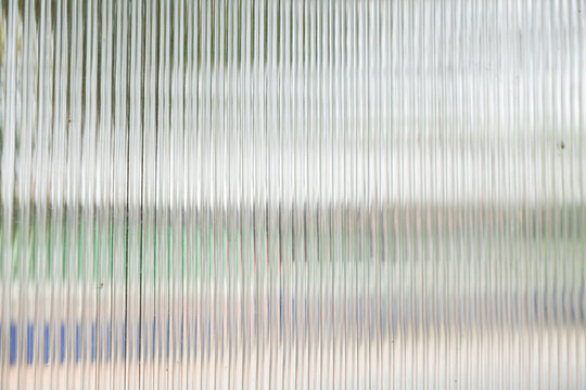 A Close up of corrugated glass texture with reflected,modern home decor,stylish home decor,Creative composition of living room,Wave glass vertical line pattern,Template.