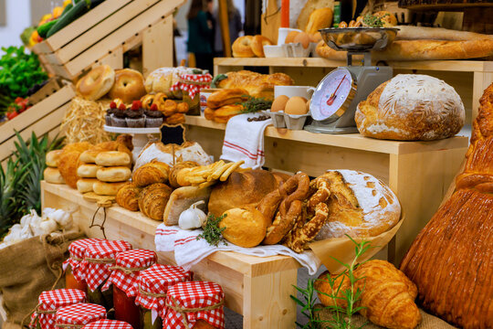 Breads, pastries, various baked goods are arranged on wooden shelves at local farm market.