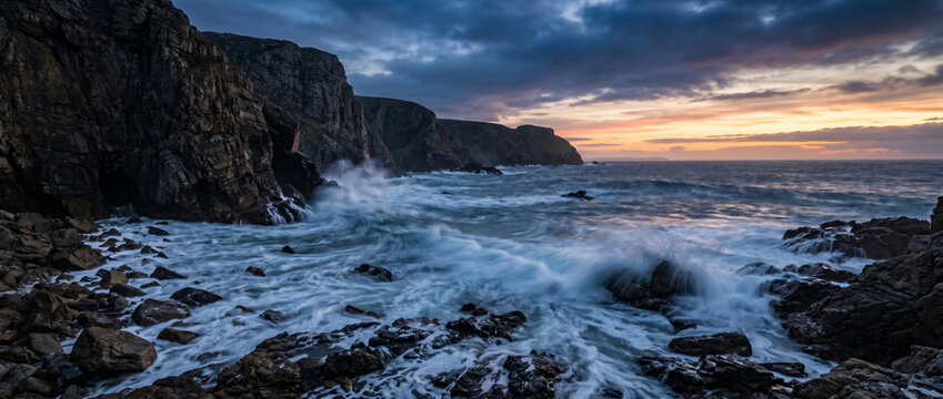 Paysage marin avec vagues percutant des falaises rocheuses au coucher du soleil