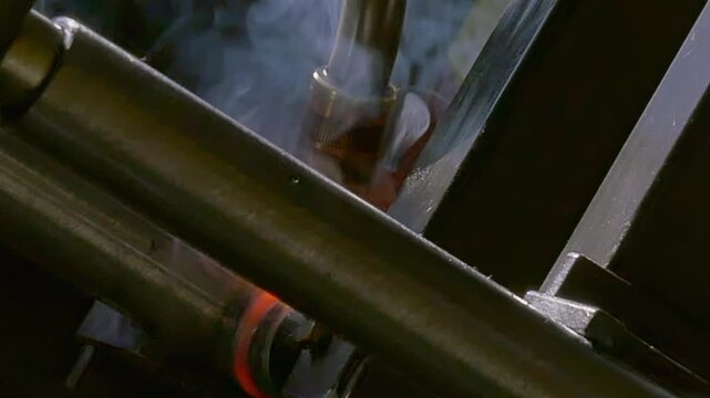 This captivating close-up showcases the precision of an industrial argon welding robot as it expertly fuses metal. Watch the sparks and smoke dance in mesmerizing slow motion.