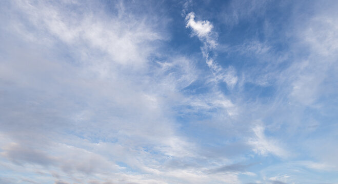 Beautiful bright blue sky with light wispy cirrus clouds texture background