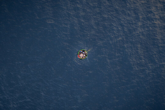 Aerial view of a traditional round basket boat floating on the deep blue waters of the South China Sea near Bai Hom, Vinh Hai, Khanh Hoa, Vietnam.