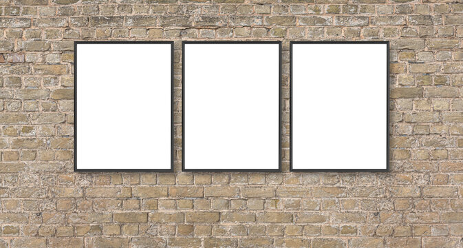 Three blank poster frames hanging on brick wall for display