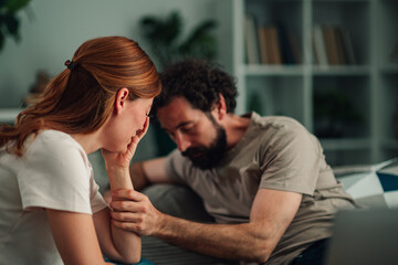 Fototapeta premium Man comforting sad woman coping with depression and mental health issues, offering support and empathy