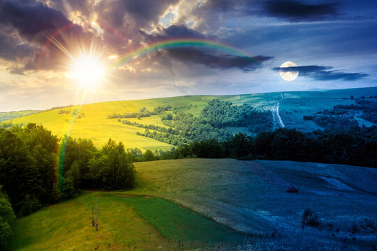 rural fields near mountain in summertime. day meet night. beautiful view of agricultural area. sun and moon in harmony over gorgeous mountain ridge with haystack on a grassy pasture. summer solstice