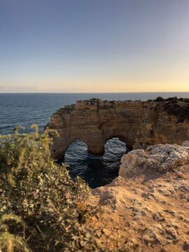 Fal&eacute;sia costeira com arco natural esculpido pelo mar que forma um cora&ccedil;&atilde;o no &acirc;ngulo certo. 