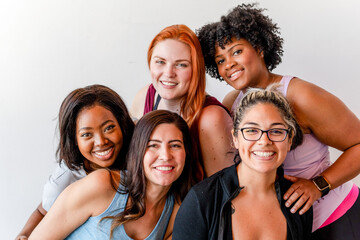 Fototapeta premium Group of diverse women smiling and posing together in casual attire.