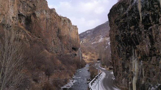 Aerial drone footage capturing the magnificent Devil's Bridge and Vorotan River Canyon in Armenia, showcasing the unique natural rock formations, towering steep cliffs,and winding scenic mountain road