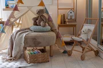 Beautiful wigwam, ottoman, different toys and books in child's room © New Africa