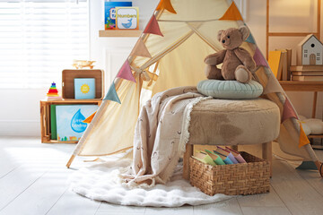 Beautiful wigwam, ottoman, different toys and books in child's room © New Africa
