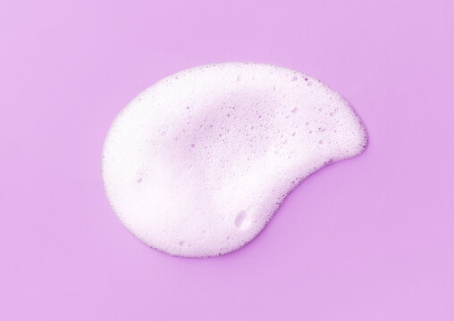White skincare cleansing foam on light purple background