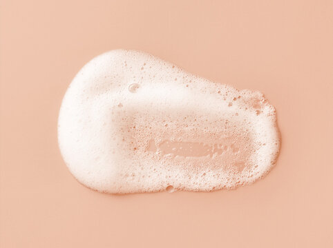 White skincare cleansing foam on light peach background