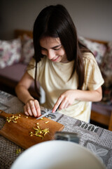 Fototapeta premium Smiling girl chopping vegetables for healthy cooking at home