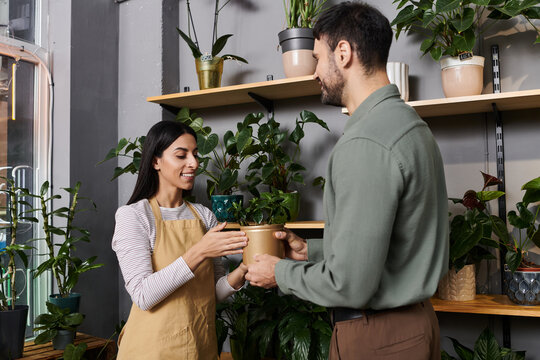 A talented florist engages with a customer, showcasing plants in a cozy flower shop.