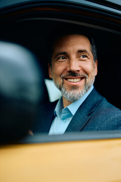 Happy businessman commuting to work by car.