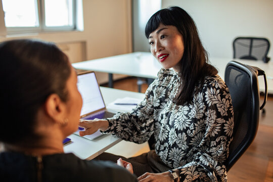 Two coworkers in one-on-one mentoring discussion at modern office