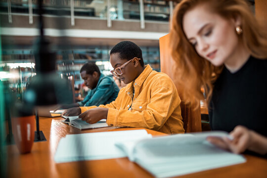 College students studying with books in university library