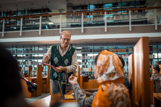 Librarian assisting students in modern university library