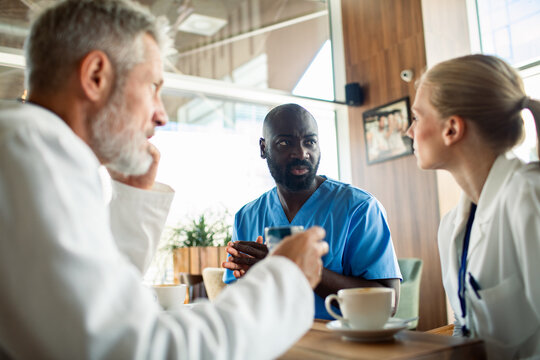 Medical team discussing work in hospital cafeteria