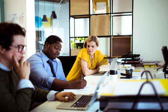 Coworkers collaborating in modern office workspace